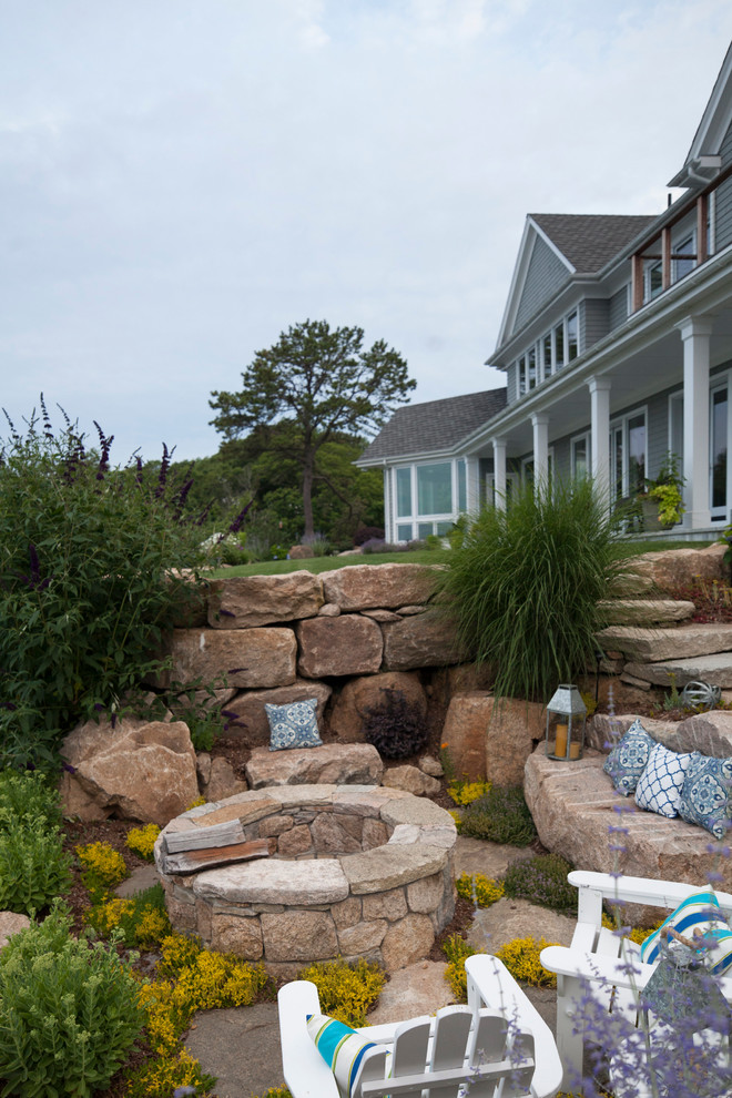 Photo of a traditional full sun backyard stone landscaping in Bridgeport with a fire pit for summer.