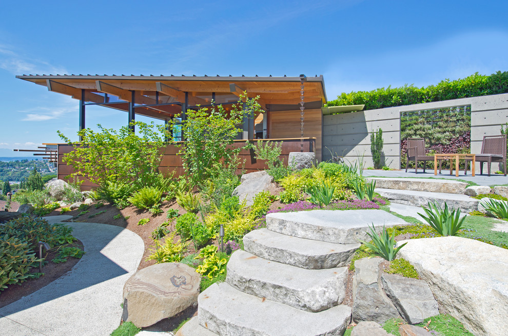 Foto di un giardino moderno esposto in pieno sole nel cortile laterale in estate con pavimentazioni in pietra naturale
