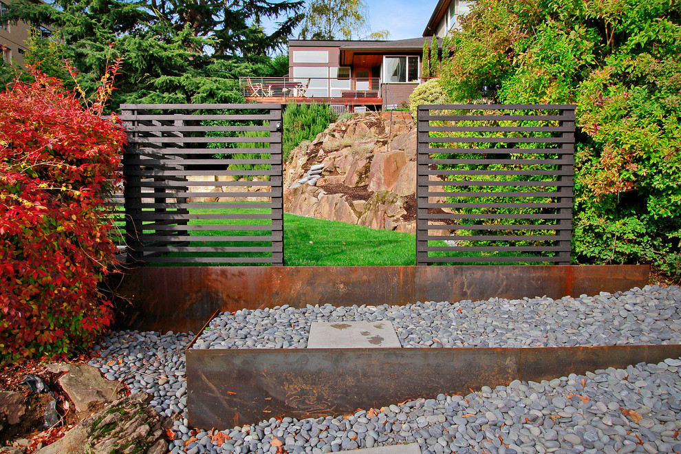 This is an example of a medium sized contemporary back partial sun garden in Seattle with a retaining wall.
