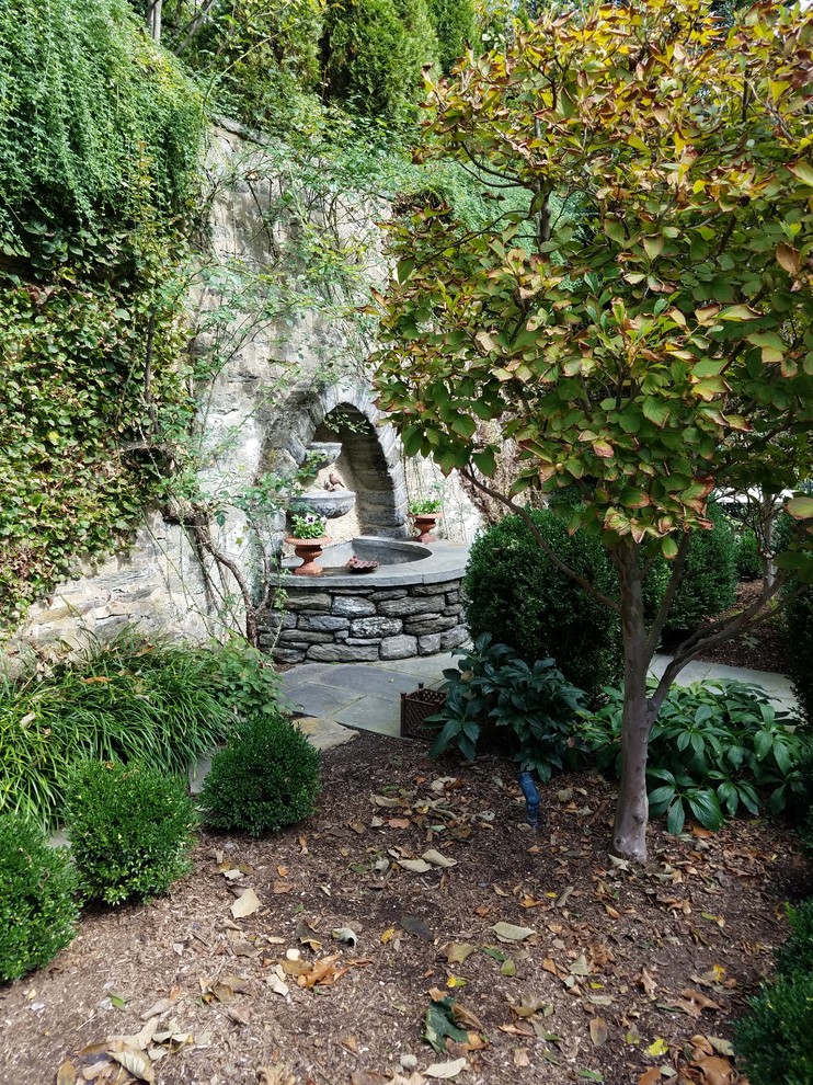 Foto de jardín tradicional pequeño en verano en patio con jardín francés, fuente, exposición parcial al sol y adoquines de piedra natural