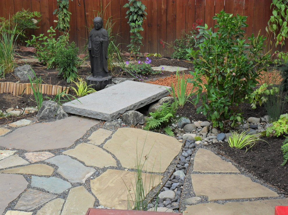Inspiration for a small world-inspired back garden in Portland with a water feature and natural stone paving.