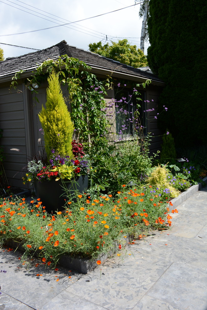 Inspiration for a mid-sized transitional full sun backyard stone vegetable garden landscape in Vancouver.
