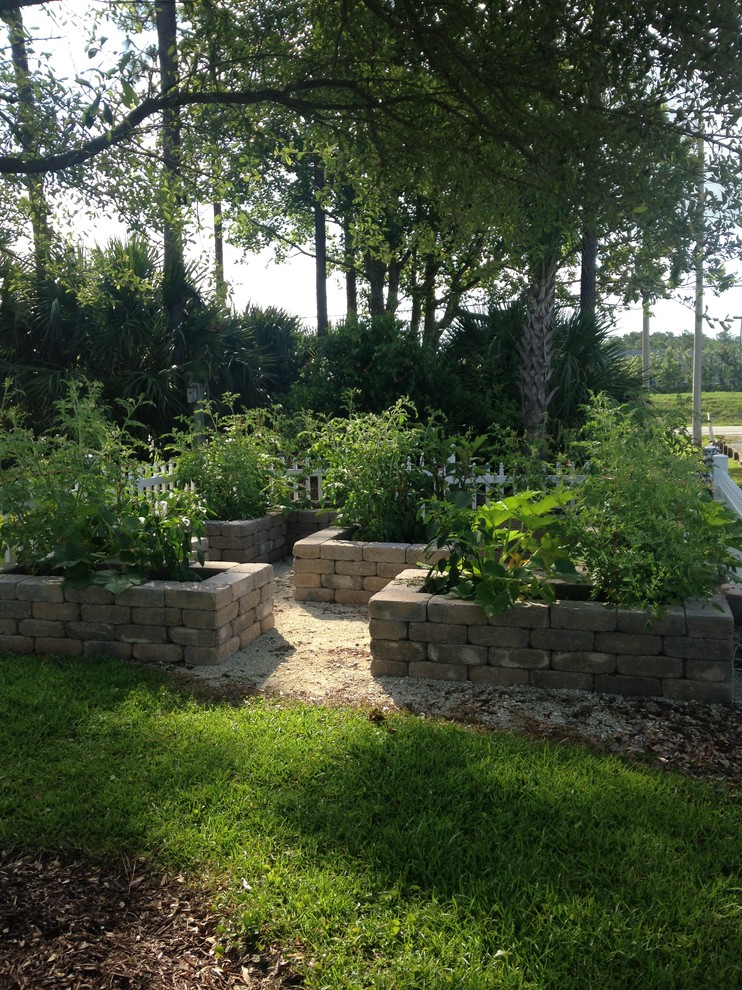 Modelo de jardín clásico de tamaño medio en primavera en patio trasero con jardín francés, jardín de macetas, exposición parcial al sol y gravilla
