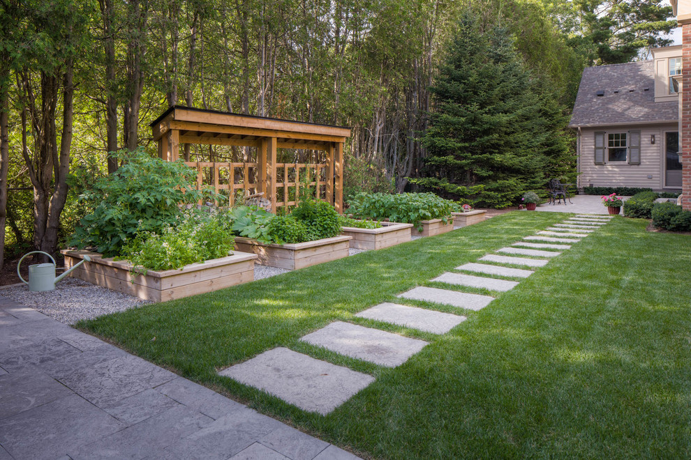 Modelo de jardín clásico renovado grande en patio trasero con huerto, exposición parcial al sol y adoquines de piedra natural