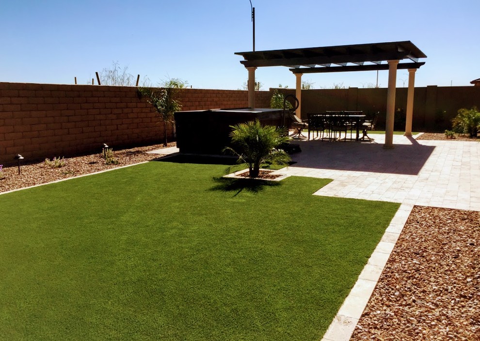 This is an example of a medium sized contemporary back xeriscape full sun garden for summer in Phoenix with natural stone paving.