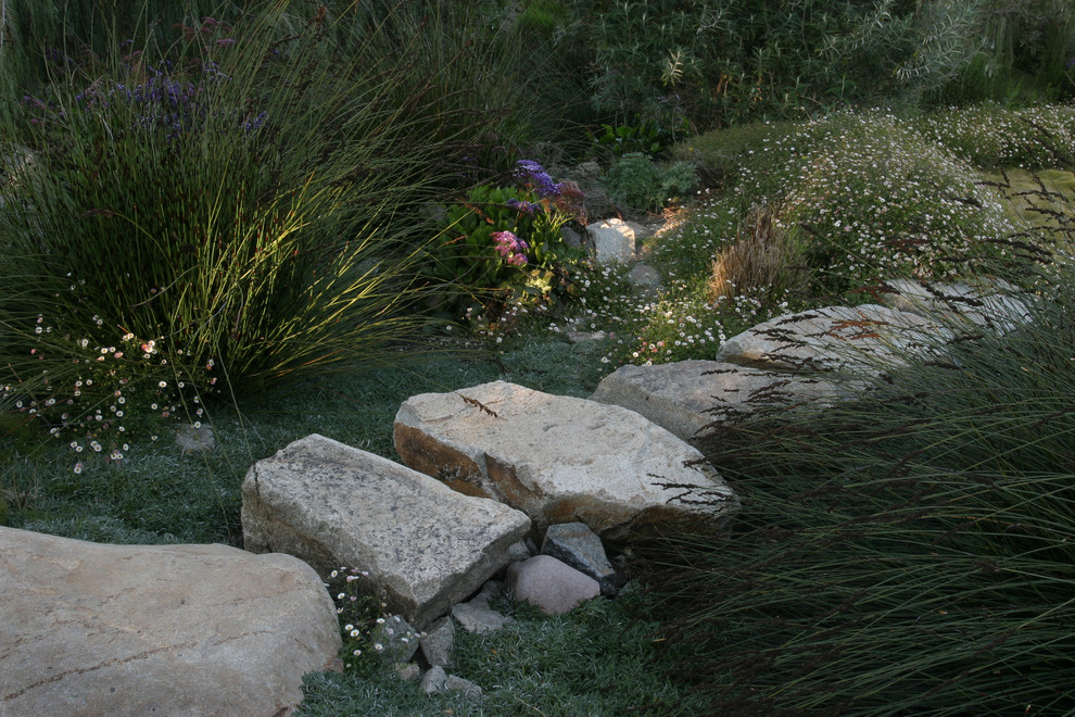 Klassischer Garten hinter dem Haus mit Wasserspiel, direkter Sonneneinstrahlung und Natursteinplatten in San Diego