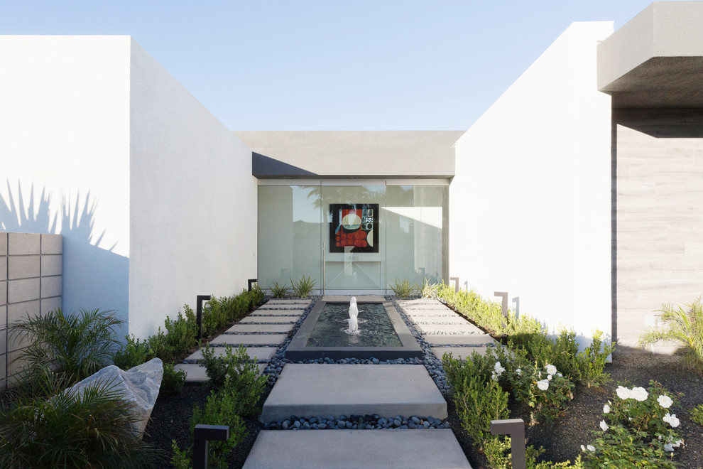 Cette photo montre un jardin moderne avec un point d'eau, une exposition partiellement ombragée et des pavés en béton.