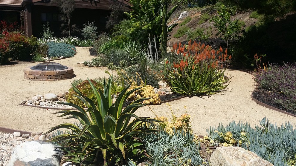 Foto de camino de jardín de secano mediterráneo grande en verano en patio lateral con exposición parcial al sol y gravilla