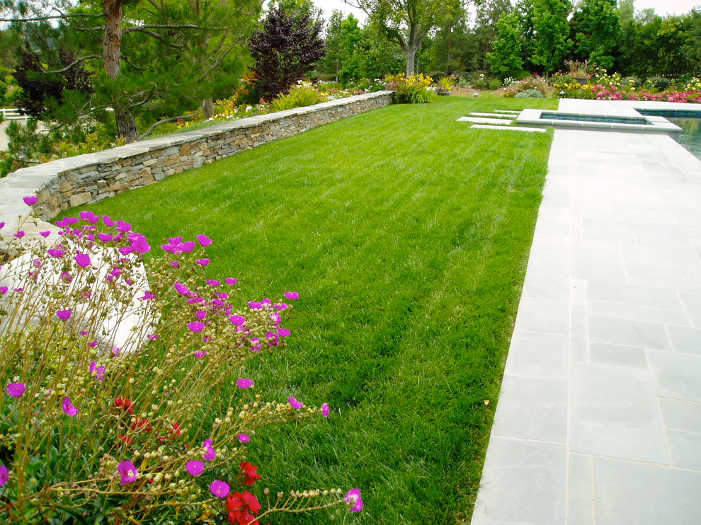 Ispirazione per un giardino tradizionale esposto in pieno sole dietro casa con pavimentazioni in pietra naturale