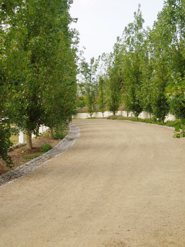 На фото: участок и сад в классическом стиле с подъездной дорогой и покрытием из гравия с