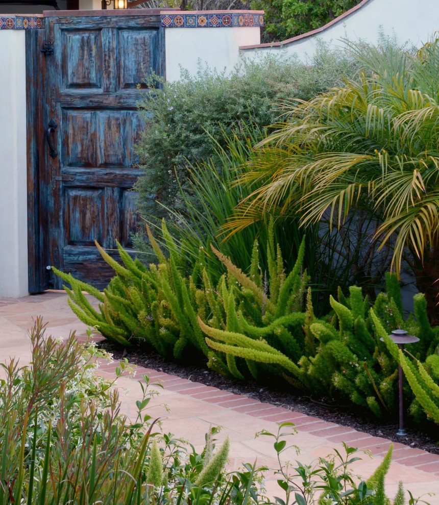 На фото: огромный участок и сад на заднем дворе в средиземноморском стиле с покрытием из каменной брусчатки и садовой дорожкой или калиткой