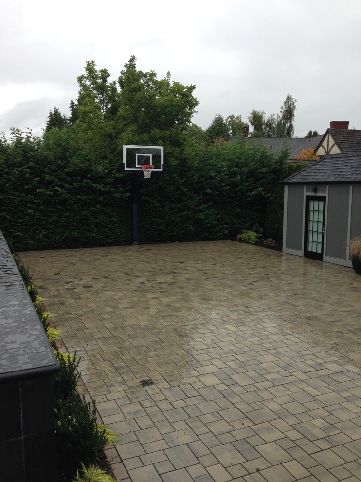 This is an example of a large classic partial sun garden in Seattle with an outdoor sport court and brick paving.