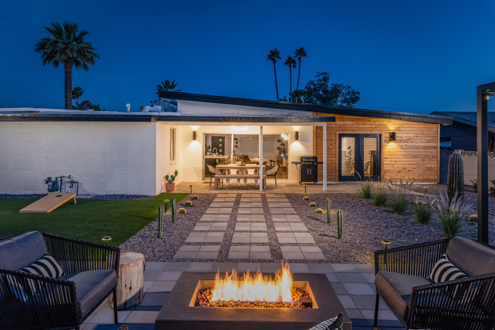 Cette image montre un jardin arrière minimaliste de taille moyenne avec un foyer extérieur et des pavés en béton.