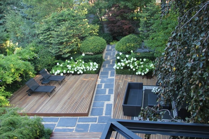 This is an example of a large modern partial sun backyard landscaping in Toronto with decking for spring.