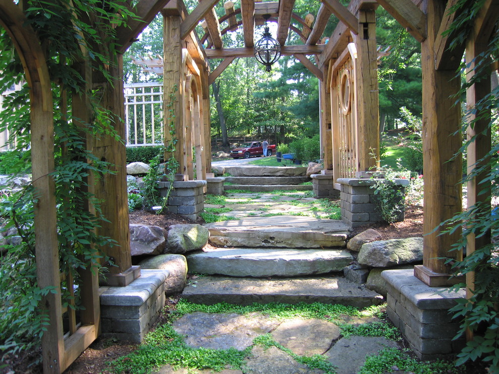 Foto på en vintage formell trädgård i skuggan i slänt, med naturstensplattor