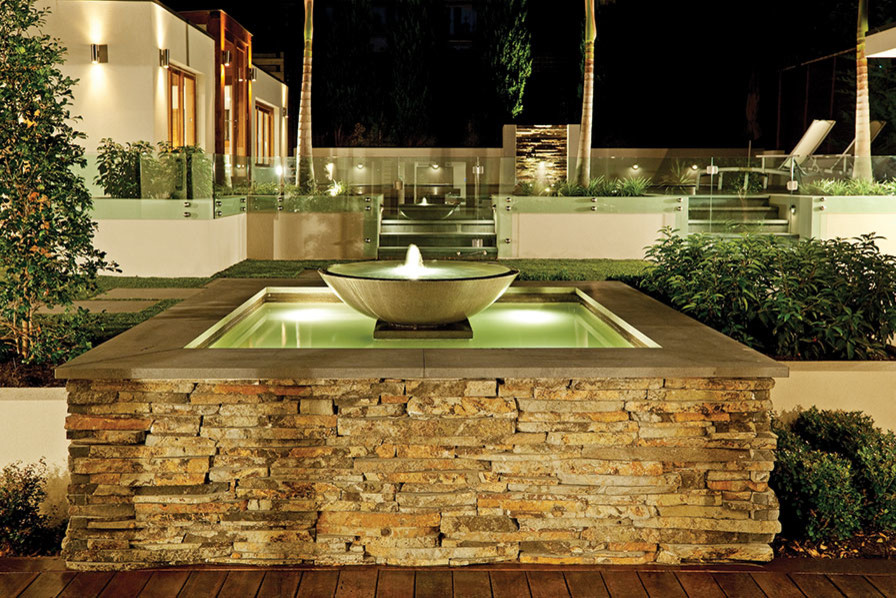 Esempio di un giardino mediterraneo di medie dimensioni e dietro casa con fontane e pavimentazioni in mattoni