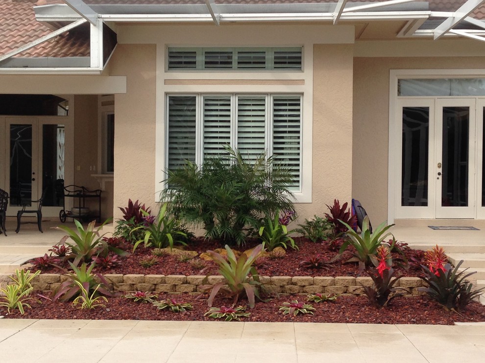 Mittelgroßer Garten hinter dem Haus, im Sommer mit Kübelpflanzen, direkter Sonneneinstrahlung und Betonboden in Miami