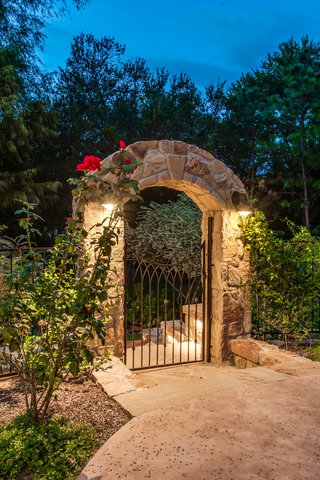 Inspiration for a rustic back full sun garden in Dallas with a retaining wall and natural stone paving.
