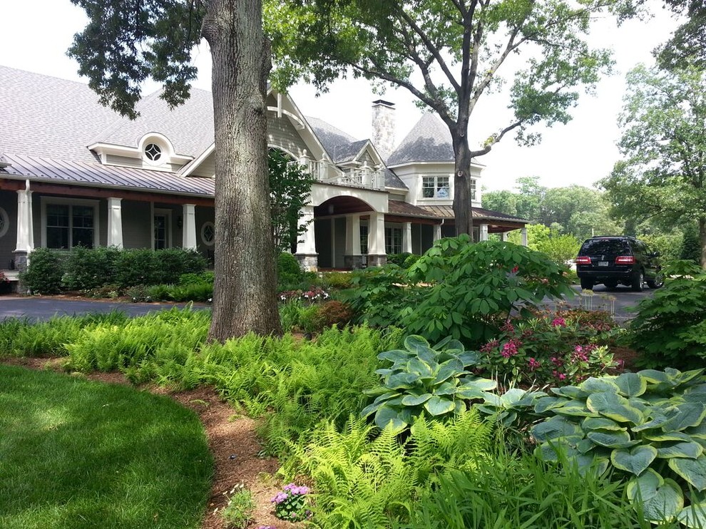 Стильный дизайн: большой участок и сад на переднем дворе в классическом стиле с подъездной дорогой и полуденной тенью - последний тренд