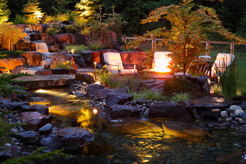 Geometrischer Uriger Garten hinter dem Haus mit Feuerstelle und Flusssteinen in Seattle