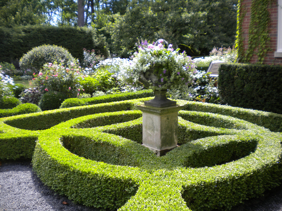Inspiration för stora klassiska formella trädgårdar i delvis sol på sommaren, med utekrukor och grus