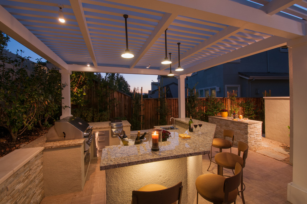 Foto de patio contemporáneo grande en patio trasero con pérgola, cocina exterior y adoquines de piedra natural
