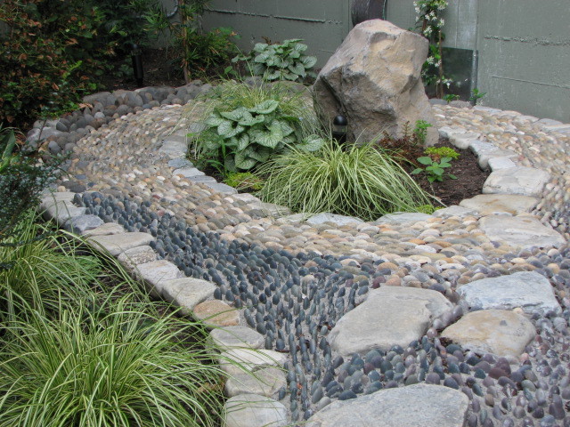 Réalisation d'un petit jardin latéral asiatique avec des pavés en pierre naturelle.