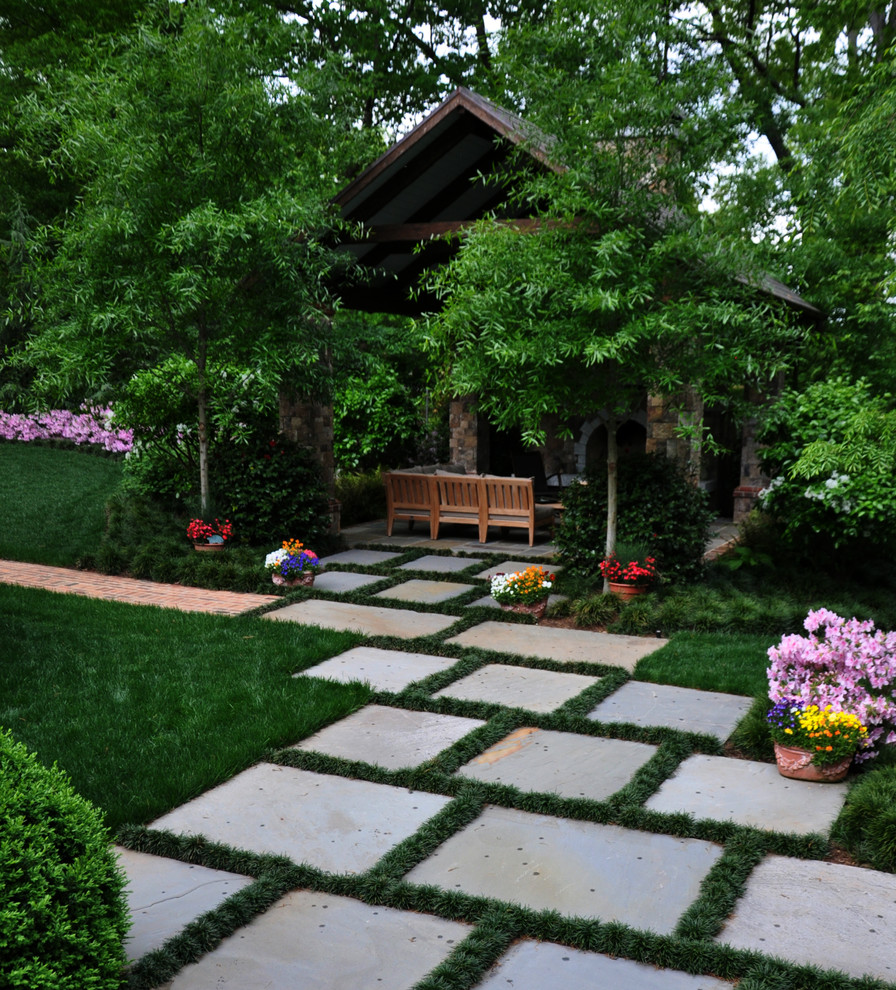 Idee per un grande giardino chic in ombra dietro casa con un focolare e pavimentazioni in mattoni