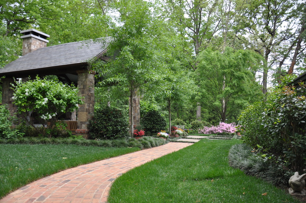 Immagine di un grande giardino tradizionale in ombra dietro casa con pavimentazioni in mattoni e un ingresso o sentiero