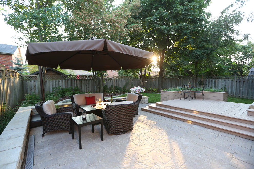 Diseño de patio clásico renovado en patio trasero con adoquines de hormigón