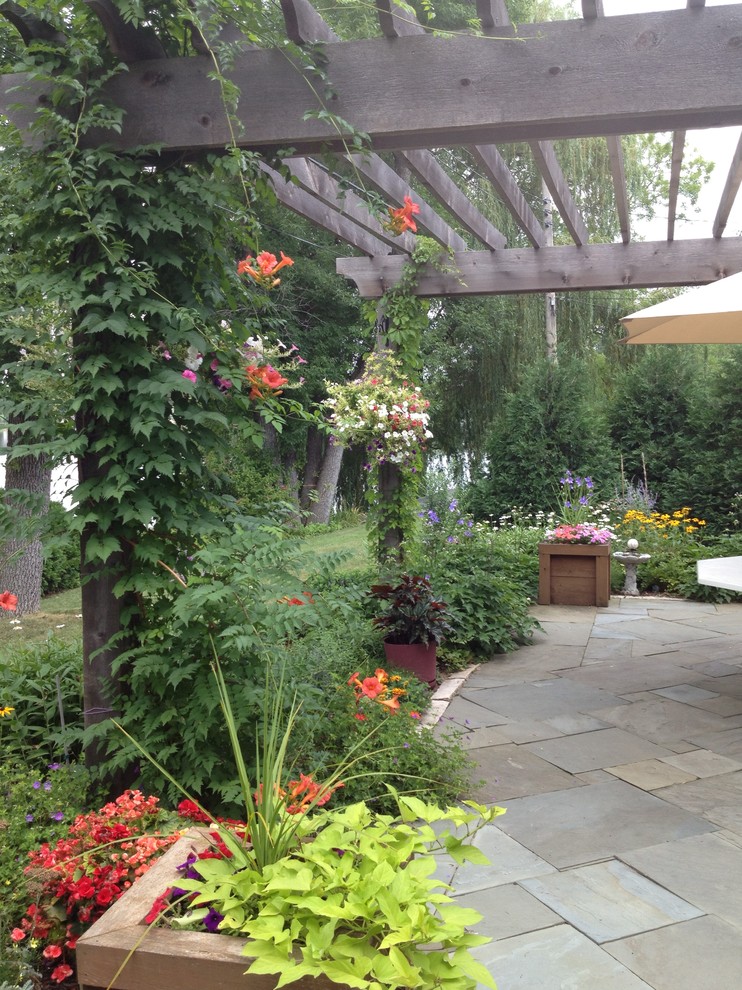 Immagine di un giardino formale chic esposto in pieno sole di medie dimensioni e dietro casa con pavimentazioni in pietra naturale e un ingresso o sentiero