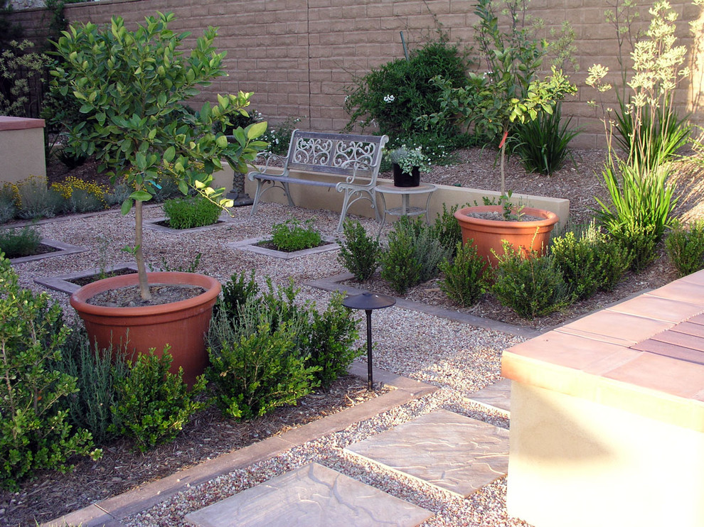 This is an example of a medium sized classic back xeriscape partial sun garden seating in Los Angeles with gravel and a potted garden.