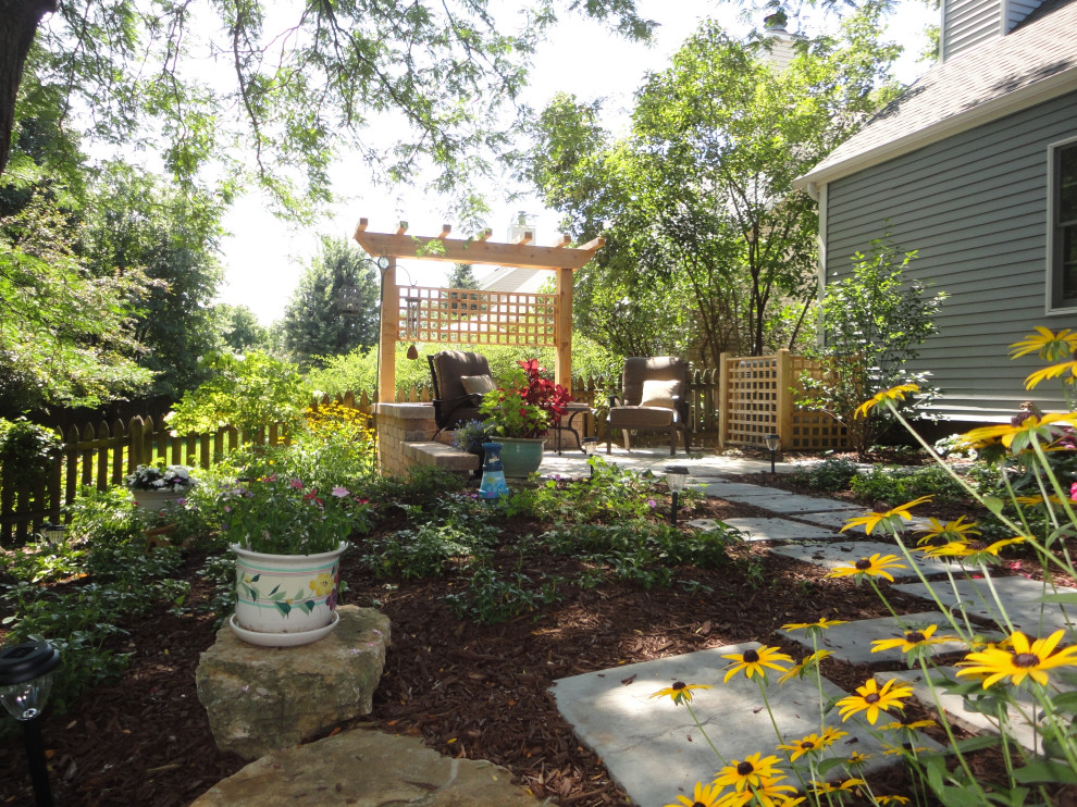 Modelo de jardín de tamaño medio en verano en patio trasero con privacidad y adoquines de ladrillo