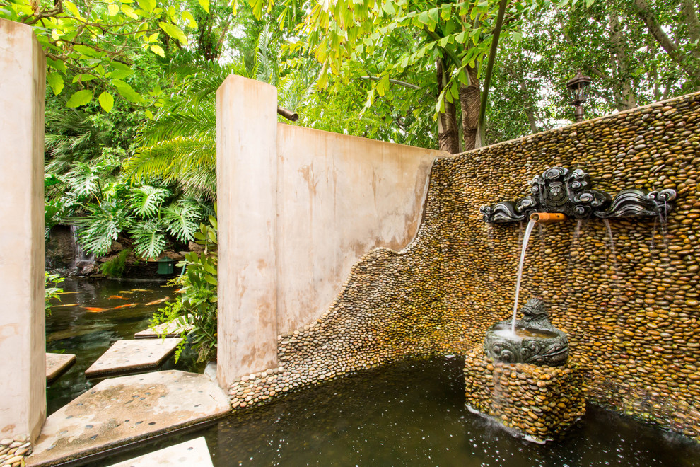 Cette image montre un grand jardin arrière asiatique avec un bassin, une exposition partiellement ombragée et des pavés en béton.
