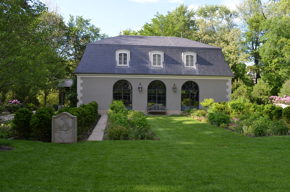 Ejemplo de jardín clásico grande en patio trasero con jardín francés