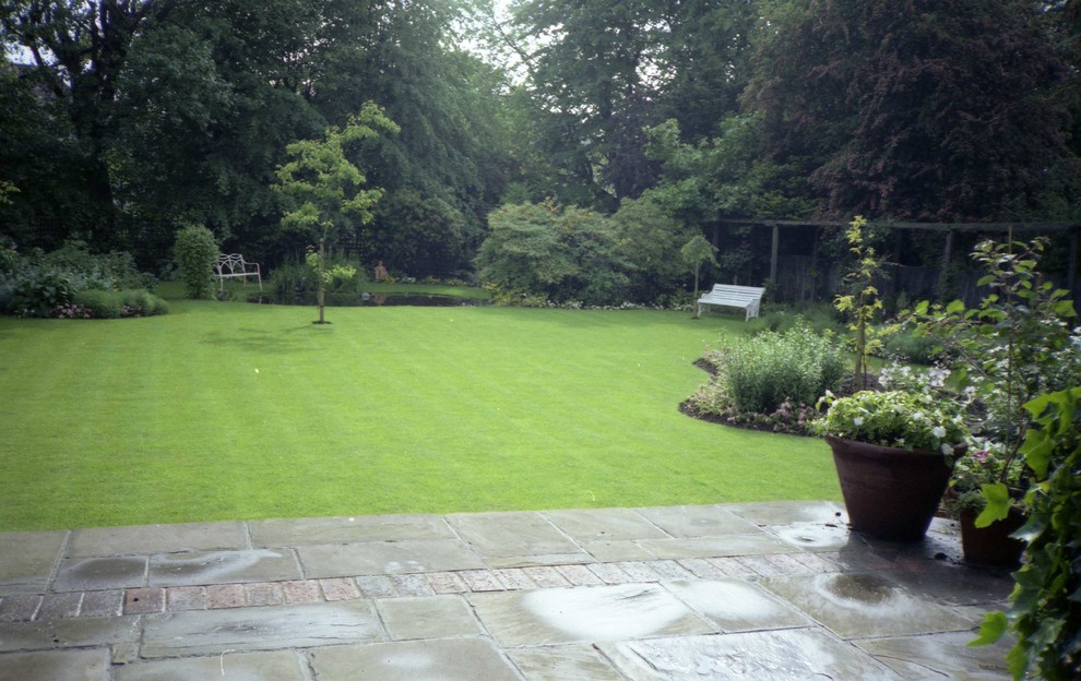 Inspiration for a mid-sized traditional partial sun backyard stone landscaping in London for summer.