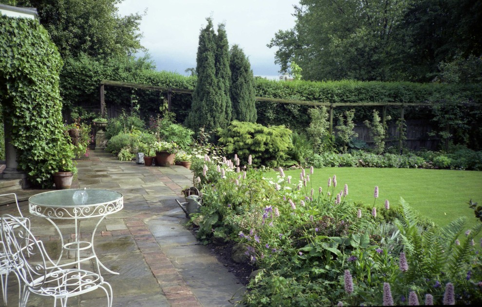 Esempio di un giardino classico esposto a mezz'ombra di medie dimensioni e dietro casa in estate con pavimentazioni in pietra naturale