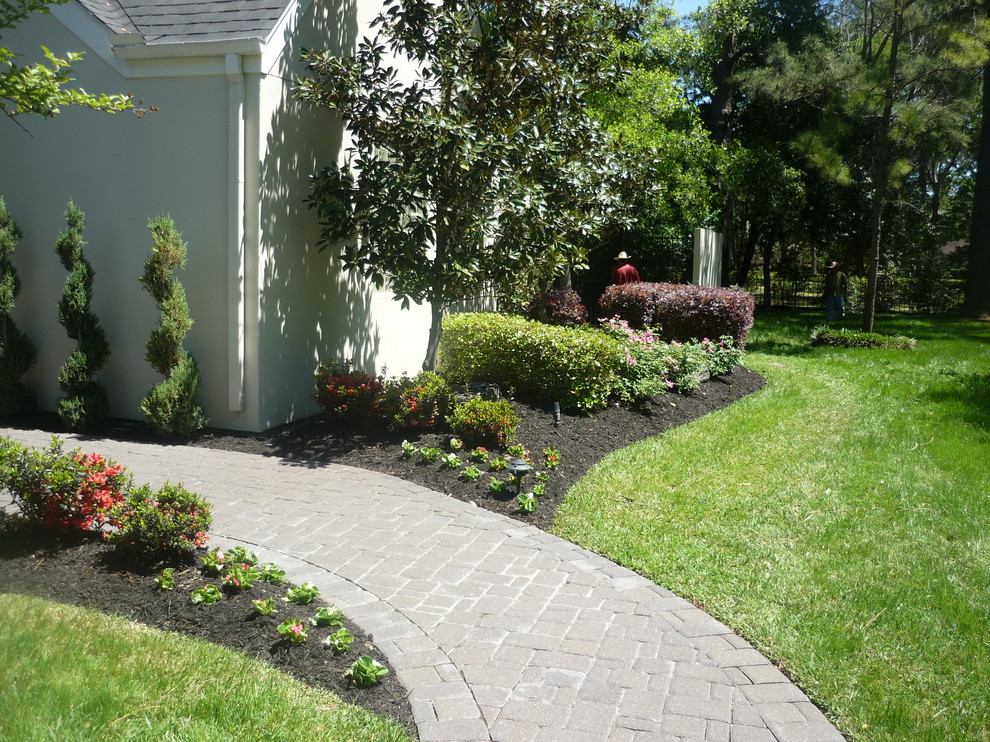 Design ideas for a mid-sized traditional partial sun front yard brick landscaping in Other for spring.