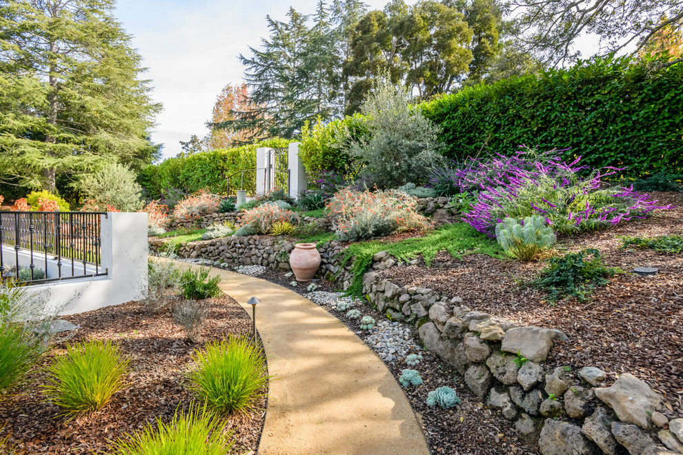 Идея дизайна: большой солнечный засухоустойчивый сад на переднем дворе в средиземноморском стиле с хорошей освещенностью и покрытием из каменной брусчатки