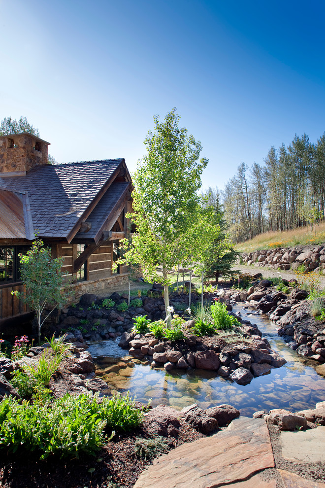 Inspiration for a rustic full sun courtyard stone water fountain landscape in Denver for summer.