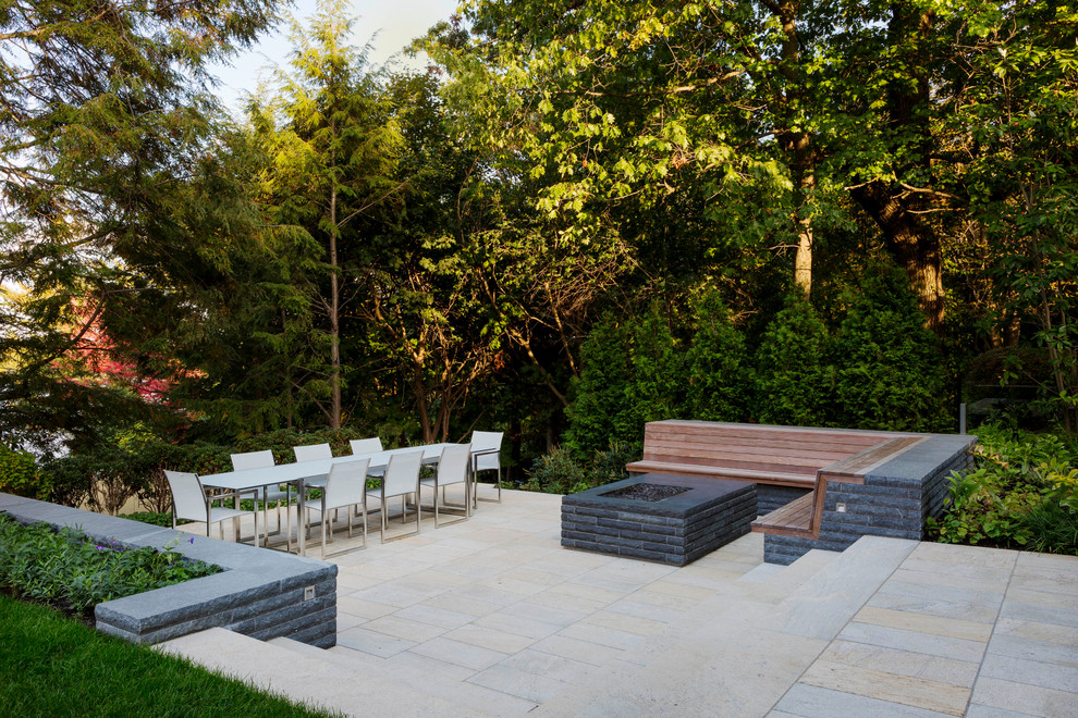 Immagine di un giardino design esposto a mezz'ombra di medie dimensioni e dietro casa con un focolare e pavimentazioni in pietra naturale
