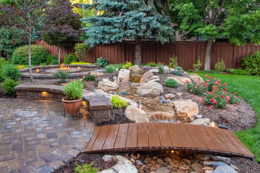 Diseño de jardín clásico de tamaño medio en patio trasero con estanque y adoquines de ladrillo
