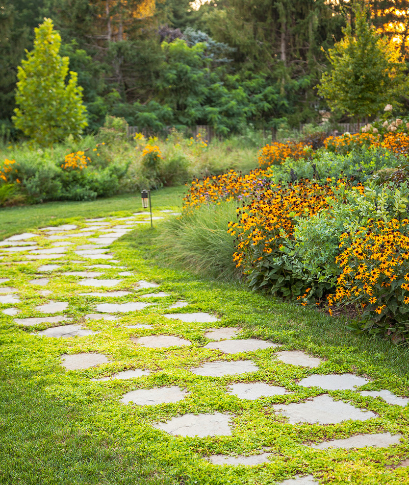Пример оригинального дизайна: солнечный засухоустойчивый сад на переднем дворе в классическом стиле с садовой дорожкой или калиткой, хорошей освещенностью и покрытием из каменной брусчатки