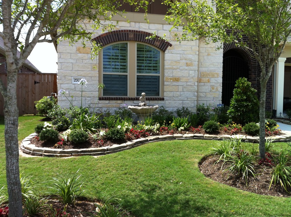 Großer Klassischer Vorgarten im Sommer mit Auffahrt, Wasserspiel, Betonboden und direkter Sonneneinstrahlung in Houston