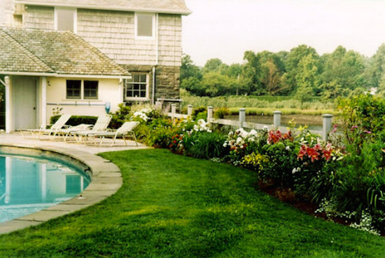 Imagen de jardín tradicional grande en patio trasero con fuente, exposición total al sol y adoquines de hormigón