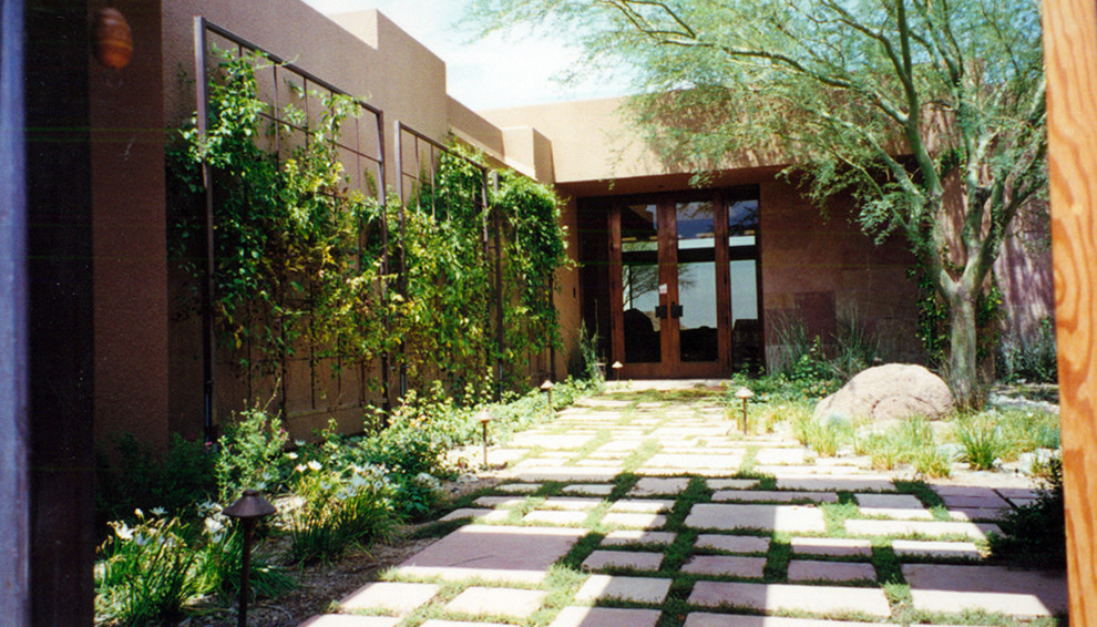 This is an example of a large contemporary front xeriscape partial sun garden for spring in Phoenix with a garden path.