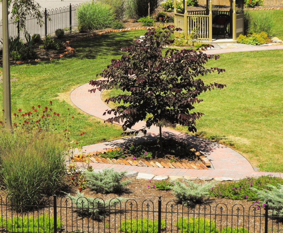 Inspiration for a mid-sized traditional full sun side yard concrete paver landscaping in Other.