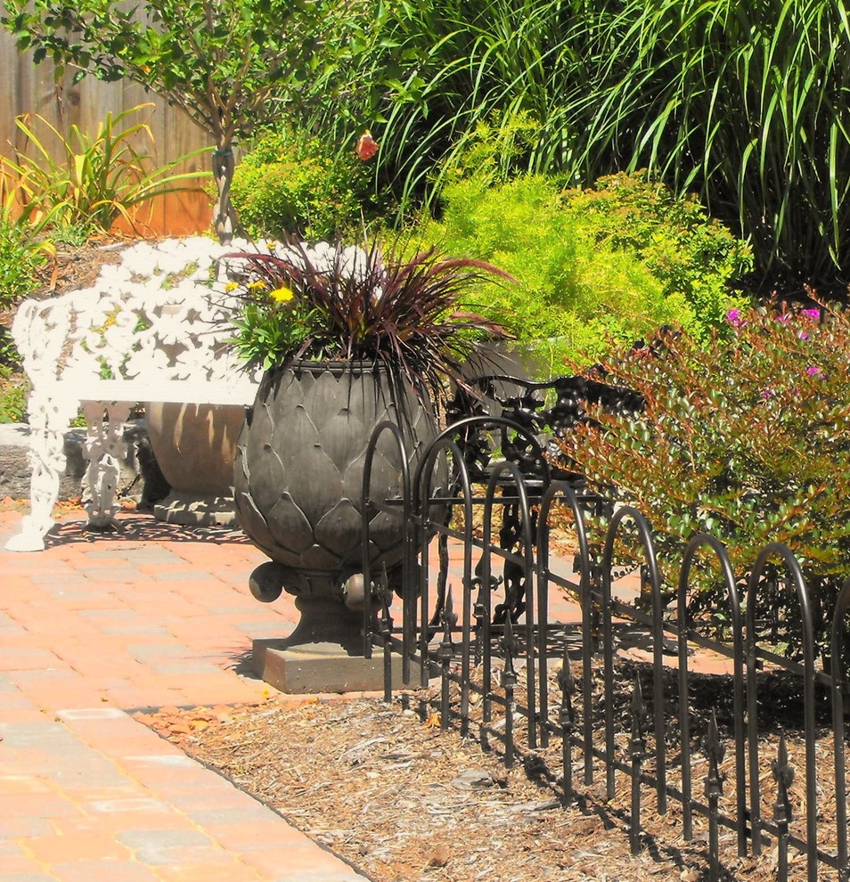 Inspiration for a mid-sized traditional full sun side yard concrete paver formal garden in Other.