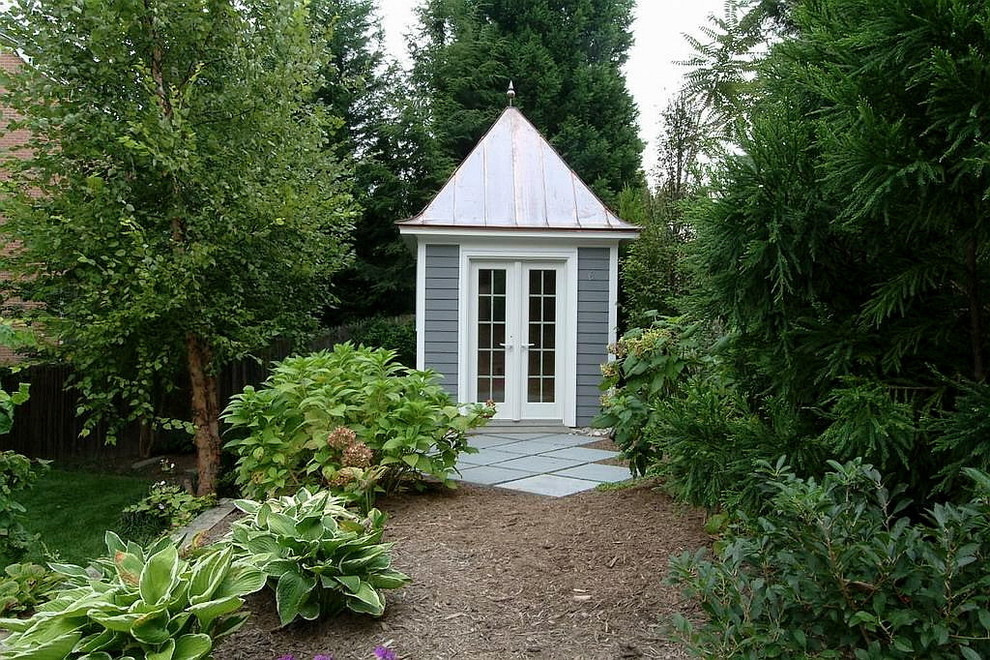 Idée de décoration pour un jardin arrière tradition de taille moyenne avec une exposition ombragée et des pavés en pierre naturelle.