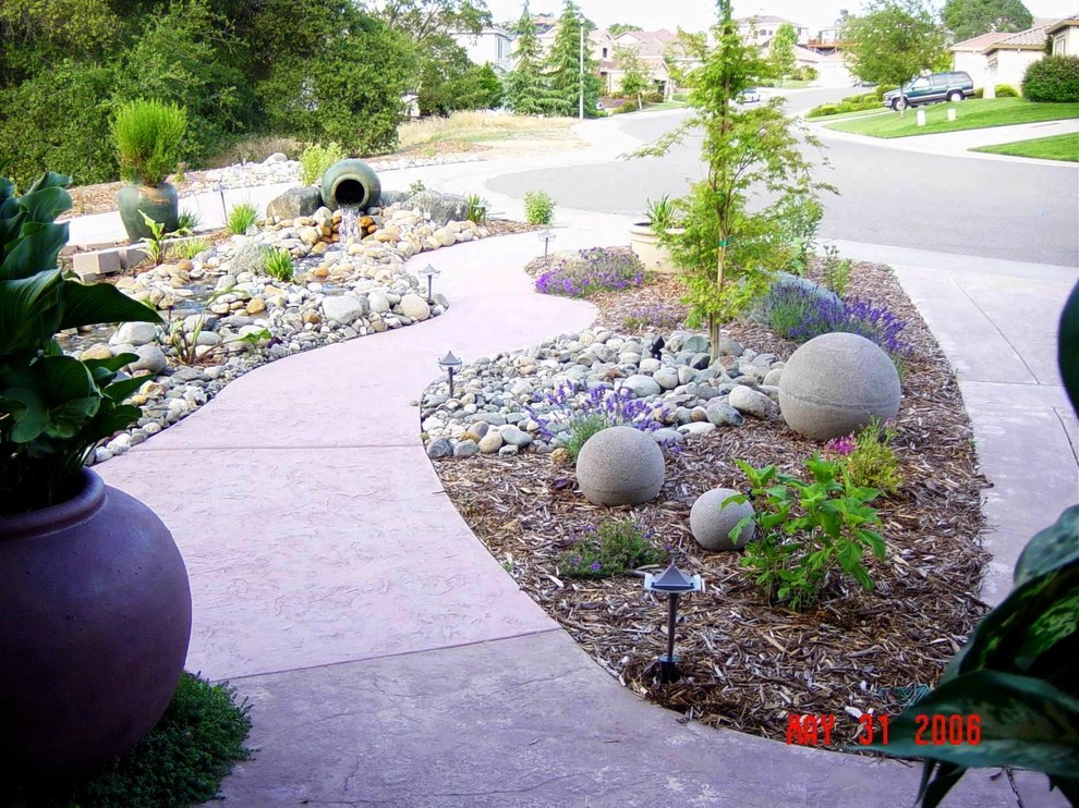 Immagine di un giardino design di medie dimensioni e davanti casa con fontane e pavimentazioni in pietra naturale